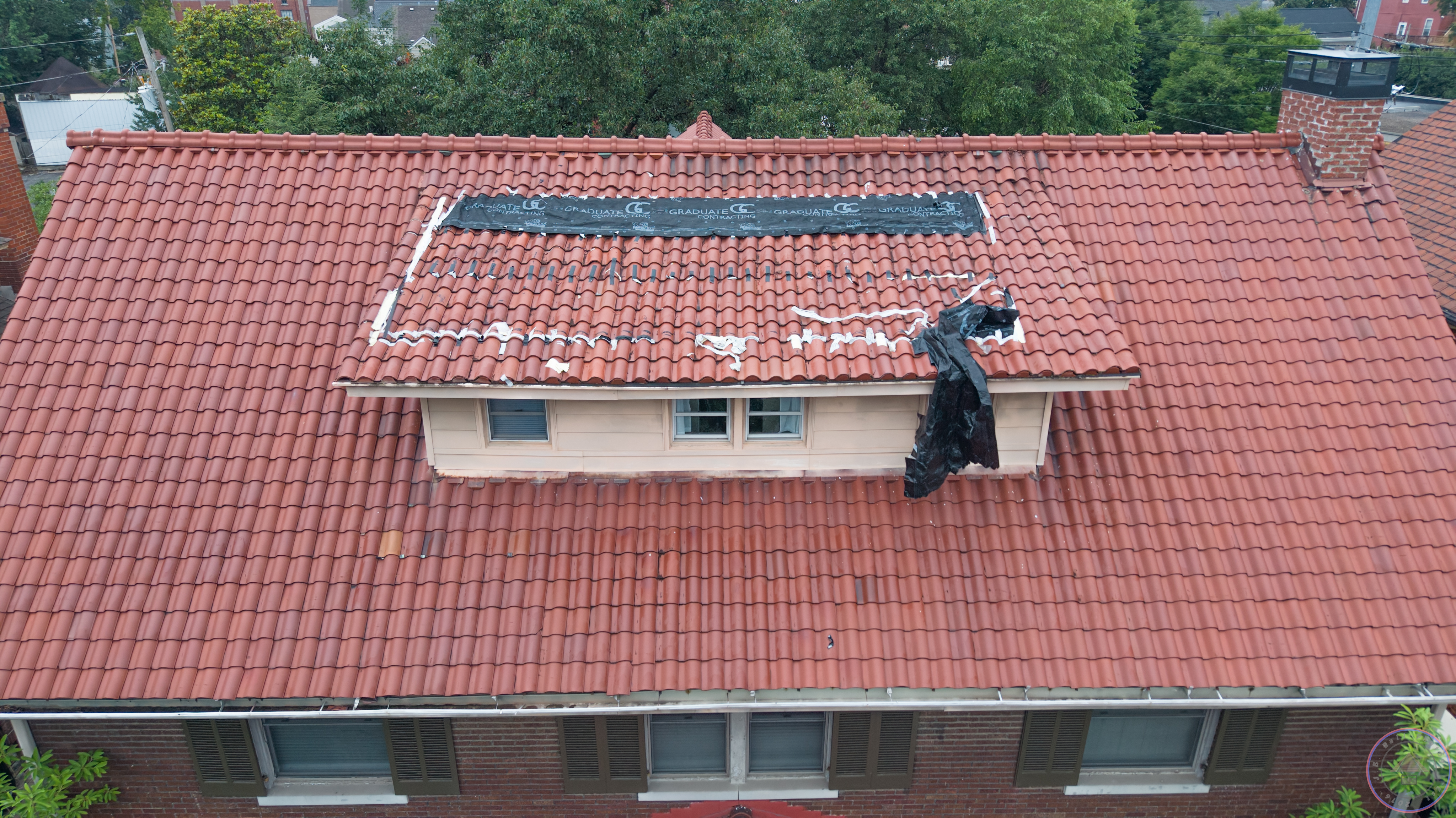 Wide aerial overview of tile roof with dormer and chimney